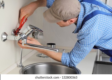 Young Craftsman Repairing Tap In A Kitchen