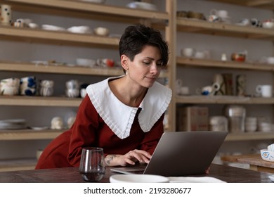 Young Craftswoman Entrepreneur Selling Ceramics Or Pottery Items Through Online Store, Female Small Business Owner Using Laptop Promoting Handmade Goods Via Social Media, Working In Art Studio