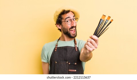 young crazy artist with brushes and wearing an apron and a beret  - Powered by Shutterstock