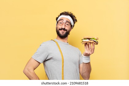young crazy bearded athlete happy expression and holding a sandwich