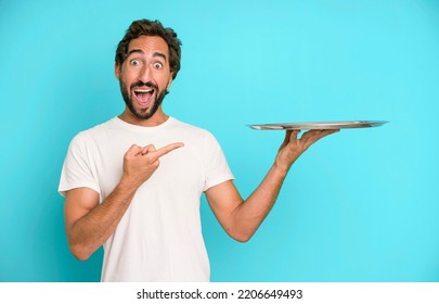 young crazy bearded and expressive man holding an empty steel tray - Shutterstock ID 2206649493