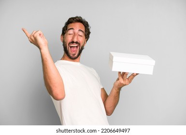 Young Crazy Bearded And Expressive Man Holding Blank Packaging Box