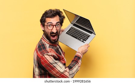 young crazy bearded man angry expression and a laptop