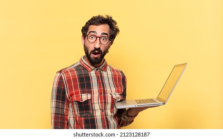 Young Crazy Bearded Man Doubting Or Uncertain Expression And A Laptop