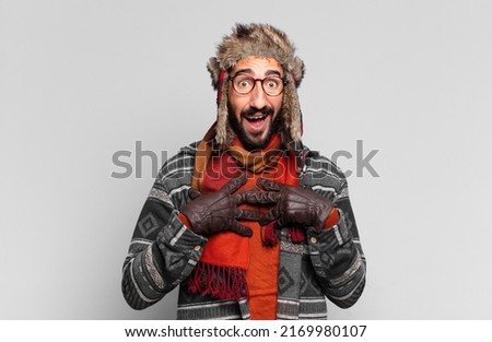 young crazy bearded man. shocked or surprised expression and wearing winter clothes