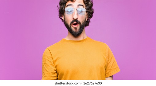 young crazy cool man feeling shocked, happy, amazed and surprised, looking to the side with open mouth against flat wall - Shutterstock ID 1627627630