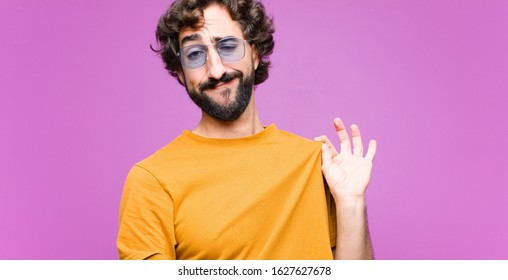 young crazy cool man looking arrogant, successful, positive and proud, pointing to self against flat wall - Shutterstock ID 1627627678