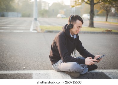 Young Crazy Funny Asian Man In Town Outdoor Lifestyle Listening Music With Headphones And Tablet