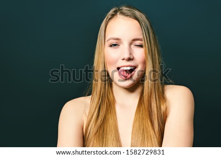 Young crazy lady. Music lover rock fan concept. Close up photo portrait of excited funky funny comic cheerful lady making stick tongue out sign isolated on a black background.