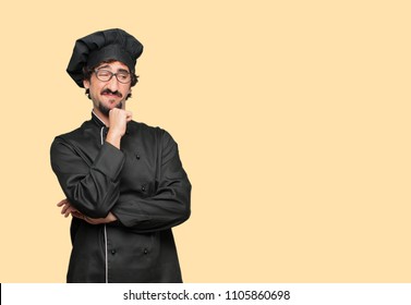 young crazy man as a chef With a confused and thoughtful look, looking sideways, thinking and wondering between different options.