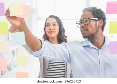 Young Creative Business Team In The Office Taking Sticky Notes From The Wall