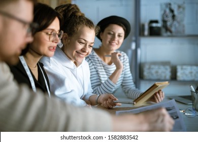Young creative fashion designers discussing new sketches while gathered in studio to work over new collection - Shutterstock ID 1582883542