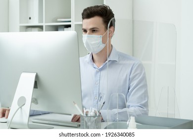 Young Creative Male Designer In Protective Mask Looking At Computer Screen While Working Over New Website By Desk In Office Environment