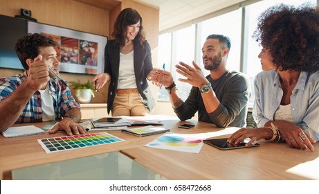 Young and creative start-up team discussing ideas in board room. Group of multi ethnic people during business meeting. - Shutterstock ID 658472668