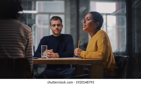 Young Creative Team Meeting with Business Partners in Conference Room Behind Glass Walls in Agency. Colleagues Sit Behind Conference Table and Discuss Business Opportunities, Growth and Development. - Powered by Shutterstock