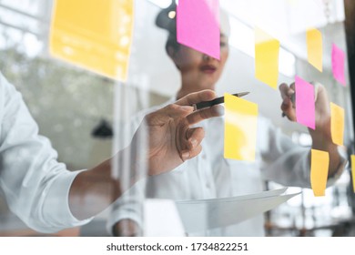 Young Creative Team Professional Using Post It Notes In Glass Wall To Writing Strategy Business Plan To Development Grow To Success.