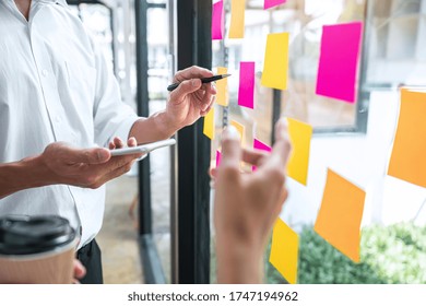 Young Creative Team Professional Using Post It Notes In Glass Wall To Writing Strategy Business Plan To Development Grow To Success.