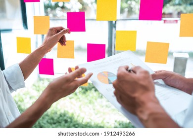 Young Creative Team Professional Using Post It Notes In Glass Wall To Writing Strategy Business Plan To Development Grow To Success.