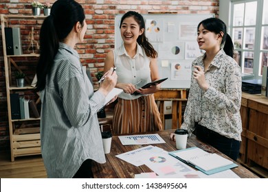 Young Creative Team Work Colleagues Ladies Discussing Ideas In Board Room. Group Of Asian Female People During Start Up Business Meeting In Studio. Three Coworkers Girls Laughing And Talking.