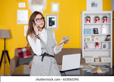 Young creative woman designer  is talking on a phone and working at office
 - Shutterstock ID 653065396