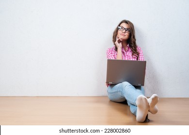 Young creative woman sitting in the floor with laptop./ Casual blogger woman - Powered by Shutterstock