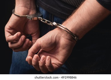 Young criminal standing in handcuffs - Shutterstock ID 491998846