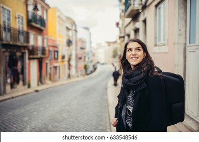 Young Curious Woman Travelling And Visiting Europe.Backpacker Touring Europe And Mediterranean Culture.Colourful Streets Of Lisbon,Portugal.Budget Traveling And Exploring Concept.Cheap Trips Concept