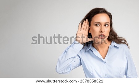 Young curiously attentive millennial woman listens closely to some spicy gossip being shared, isolation yellow studio background, panorama. Lifestyle at work, news and information
