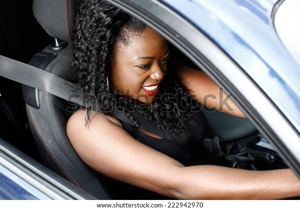 Young Curly Hair Black Woman in Sleeveless Driving\
a Car in Safety Seat\
Belt.
