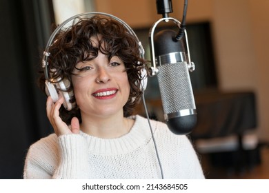 A young curly hair singer woman recording a song in a real studio - Shutterstock ID 2143684505