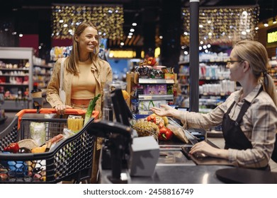 Young customer woman wear casual clothes talk with seller at checkout shopping at supermaket store grocery shop buy with trolley cart choose products in hypermarket. Purchasing food gastronomy concept - Powered by Shutterstock