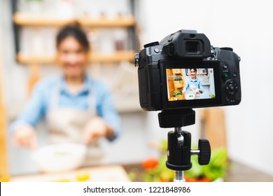 Young Cute Asian Blogger Girl Recording Video Tutorial Session Of Salad Cooking Lesson At Home Kitchen. Food Blogging Or Vlogging, Social Media Hobby Broadcasting, Or Online Learning Course Concept