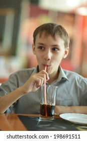 Young Cute Boy Drink Coke In Cafe