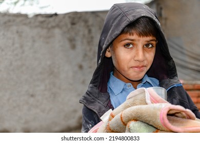 A Young Cute Boy Is Receiving Blanket By A Charity Relief Work 