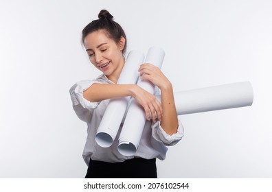 Young and cute business woman holds blueprints in her hands. She loaded with projects or overwhelmed with work, drops out of hands the blueprints isolated on white copy space
