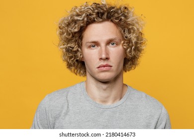 Young cute calm cool blond caucasian european serious attractive man 20s he wearing basic grey t-shirt looking camera isolated on plain yellow color background studio portrait. People lifestyle concept - Powered by Shutterstock