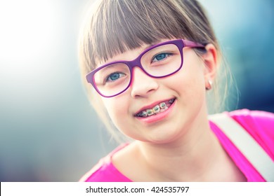 Young Cute Caucasian Blond Girl With Dental Braces And Glasses. 