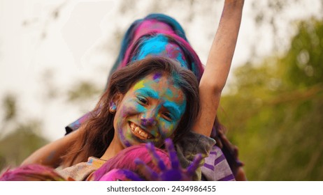 Young cute cheerful little girl kid with applied holi colors powder showing colorful hands to camera during holi festival celebration - Powered by Shutterstock