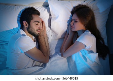 Young cute couple sleeping together in bed