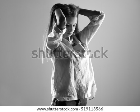 fashionable girl in black glasses sitting on an iron barrel