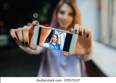 Young Cute Girl Taking Selfie On The Phone Outside