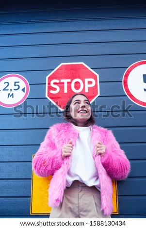 young cute girl teenager gesturing hanging around city parking and teasing with stop sign, lifestyle people concept