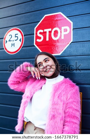 young cute girl teenager gesturing hanging around city parking and teasing with stop sign, lifestyle people concept