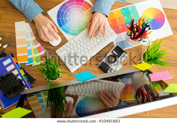 Young cute Graphic designer using graphics tablet to\
do his work at desk