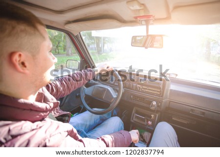 young cute guy is driving a car, toned