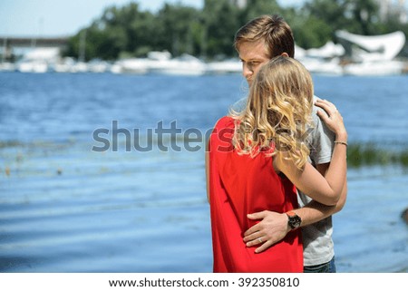 Young and cute happy couple hugging and laughing on river background