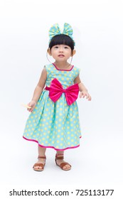 Young Cute And Lovely Little Korean Girl (or Little Kid) Wearing Green Blue (or Soft Blue) Dress With Polka Dot Pattern And Belting Red Bow (like A Korean Hanbok) Standing On White Background