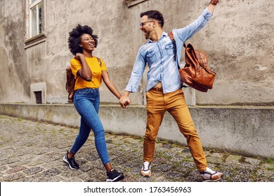 Young cute multicultural couple taking a walk in an old part of the town.