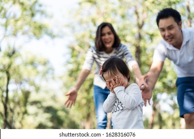 Young Cute Sad Little Asian Toddler Girl Crying In Park. Mother And Father Running To Child And Taking Care Of Daughter By. Parent Feeling Scared And Afraid Of Kid Having Injury, Family Relation.