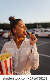 Young Cute Woman Holding Popcorn In A Shopping Mall Parking Lot